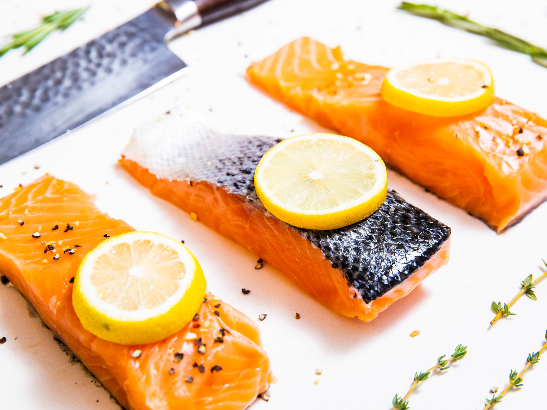 Salmon filets with lemon slices and herbs.